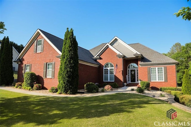 view of front of house featuring brick siding and a front yard