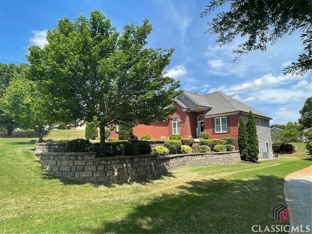 view of front facade featuring brick siding and a front yard
