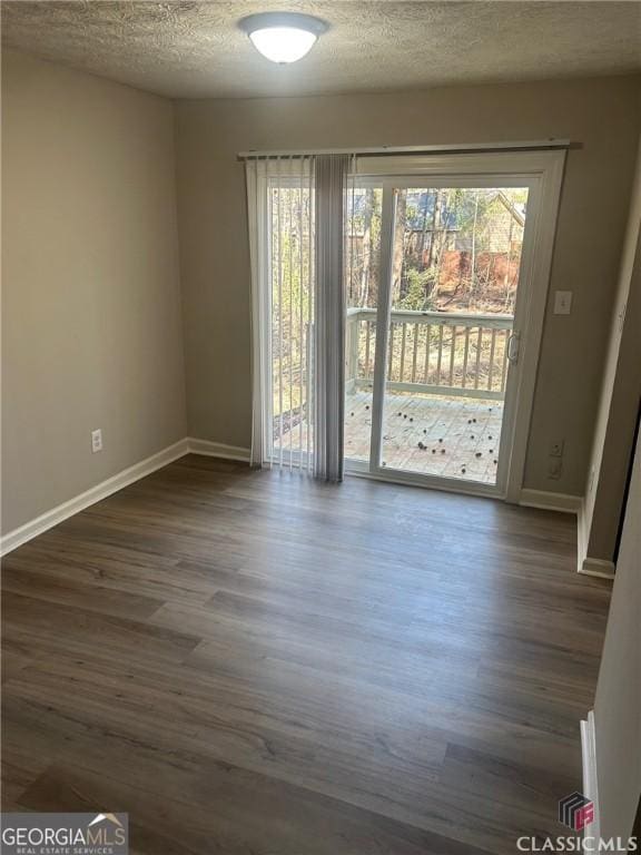 435 Rustwood Dr, Athens, GA 30606 - empty room with dark wood finished floors, baseboards, a textured ceiling, and plenty of natural light