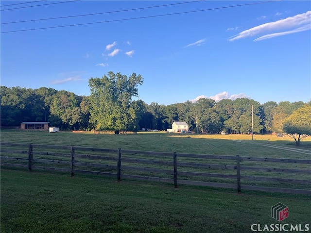 view of yard featuring fence and a rural view