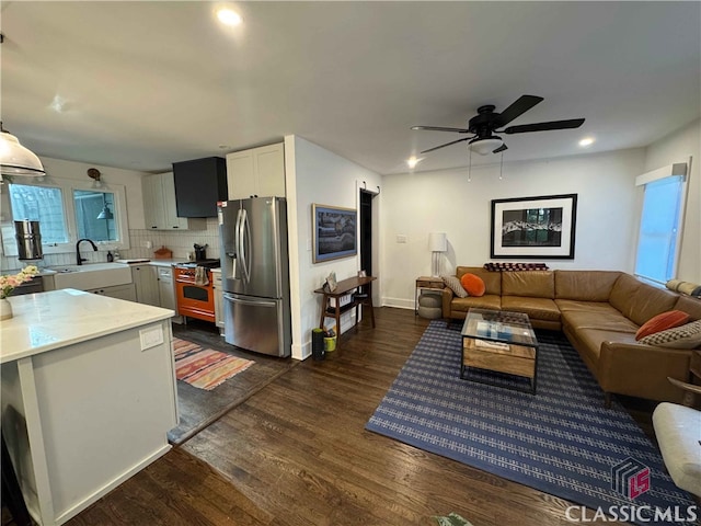 living room featuring recessed lighting, ceiling fan, baseboards, and dark wood finished floors