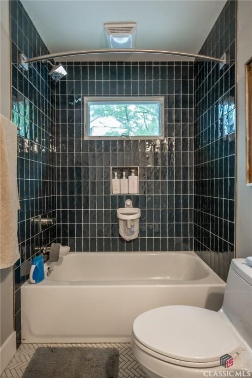 bathroom featuring tile patterned flooring, toilet, and shower / tub combination