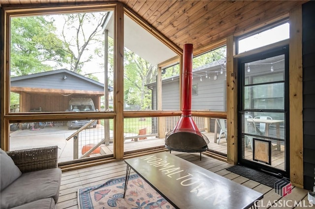sunroom / solarium featuring a wooden deck, vaulted ceiling, hardwood / wood-style flooring, and wood ceiling