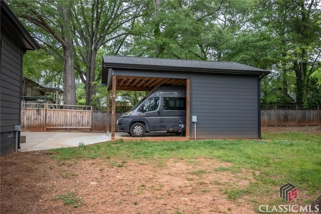 view of parking / parking lot with fence and a carport