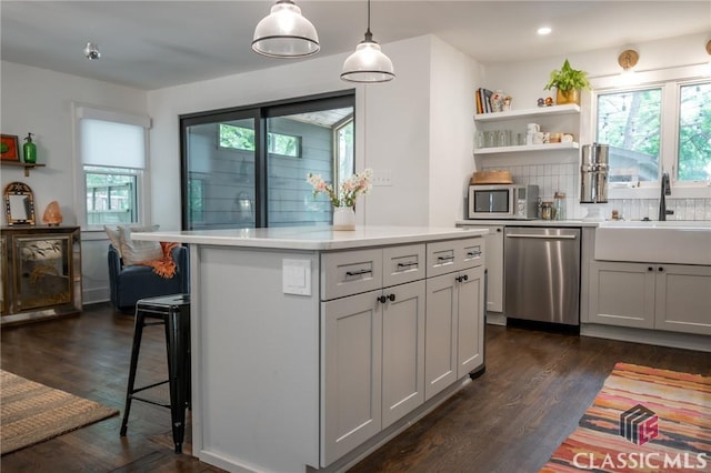kitchen featuring a sink, dark wood-style flooring, stainless steel appliances, and light countertops