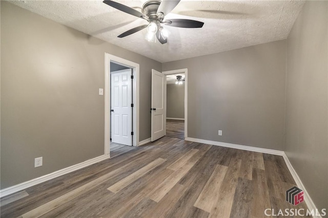 451 N Woodlawn Dr, Crawford, GA 30630 - unfurnished bedroom with wood finished floors, a textured ceiling, a ceiling fan, and baseboards