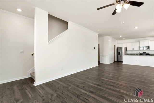unfurnished living room with dark wood-type flooring, stairs, ceiling fan, and crown molding
