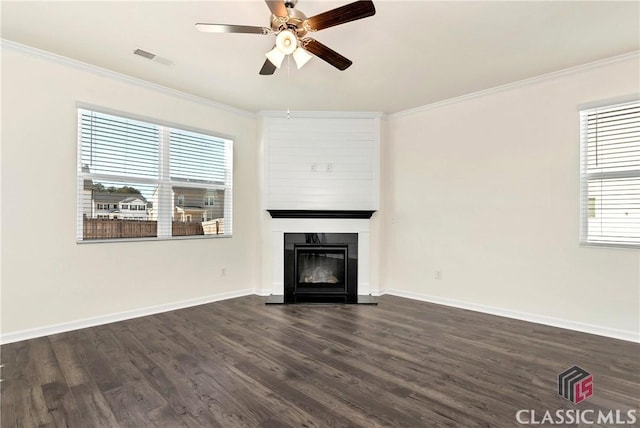 unfurnished living room featuring ornamental molding, a wealth of natural light, a ceiling fan, and a large fireplace