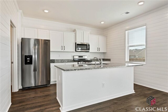 kitchen with light stone countertops, stainless steel appliances, visible vents, and white cabinetry