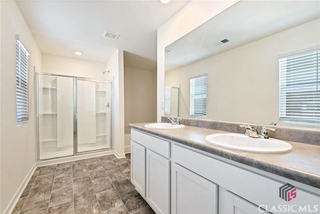 bathroom with a shower stall, visible vents, baseboards, and a sink