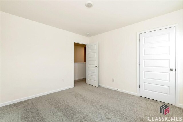 unfurnished bedroom with baseboards and carpet