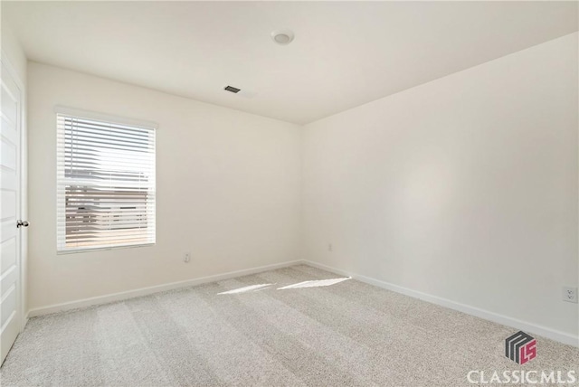 empty room with light carpet, visible vents, and baseboards