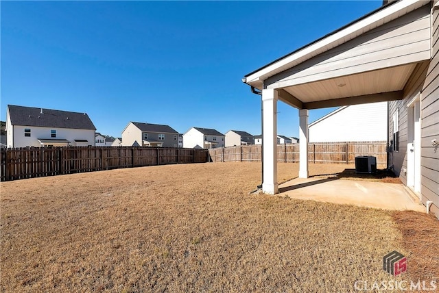 view of yard with a patio area, a fenced backyard, cooling unit, and a residential view