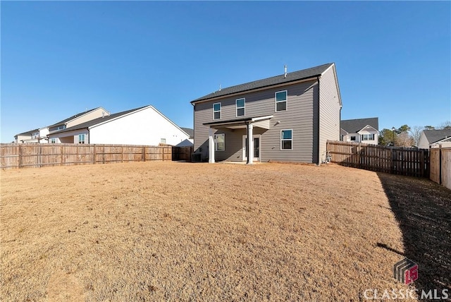 rear view of property with a fenced backyard