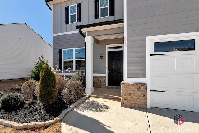 doorway to property with board and batten siding and a garage