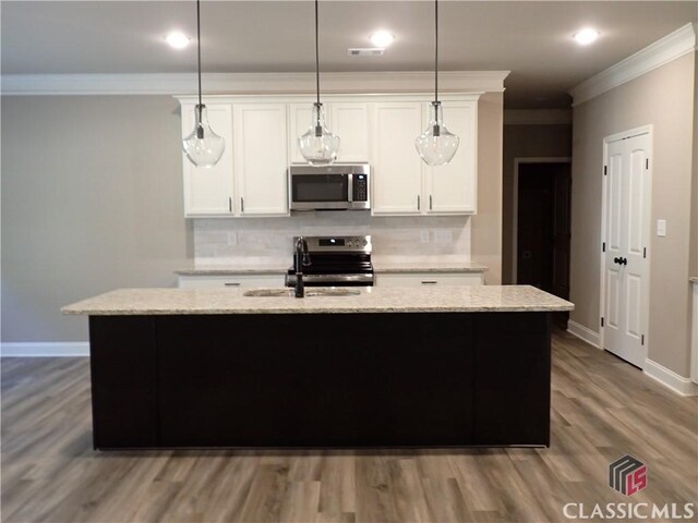41 Hometown Ct, Jefferson, GA 30549 - kitchen with a sink, appliances with stainless steel finishes, a center island with sink, backsplash, and ornamental molding