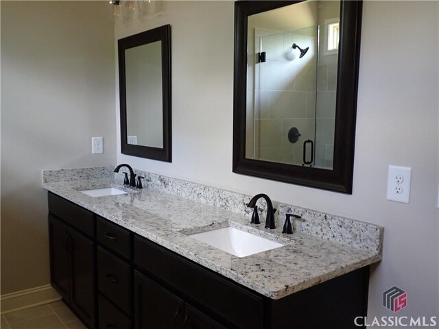 37 Hometown Ct, Jefferson, GA 30549 - bathroom with baseboards, double vanity, a stall shower, and a sink