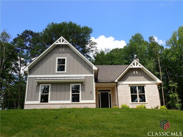 45 Hometown Ct, Jefferson, GA 30549 - view of front of property featuring roof with shingles, a front lawn, board and batten siding, brick siding, and a standing seam roof