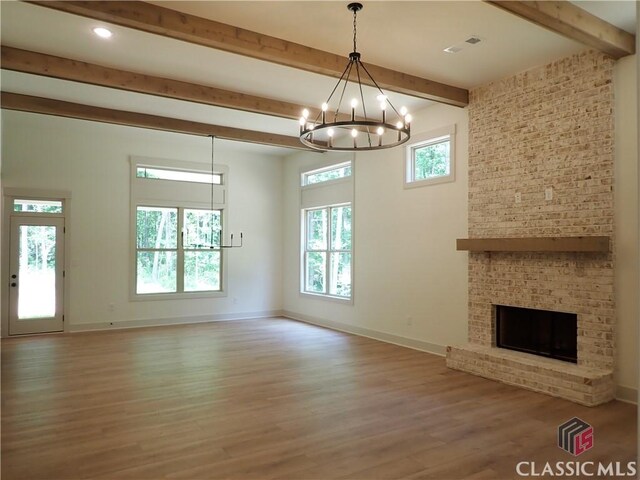 45 Hometown Ct, Jefferson, GA 30549 - unfurnished living room with beamed ceiling, wood finished floors, a chandelier, and a healthy amount of sunlight