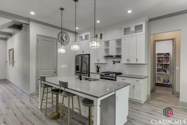 4208 Sierra Creek Ct, Hoschton, GA 30548 - kitchen with stainless steel gas range, wall chimney range hood, black fridge, crown molding, and light wood-style floors