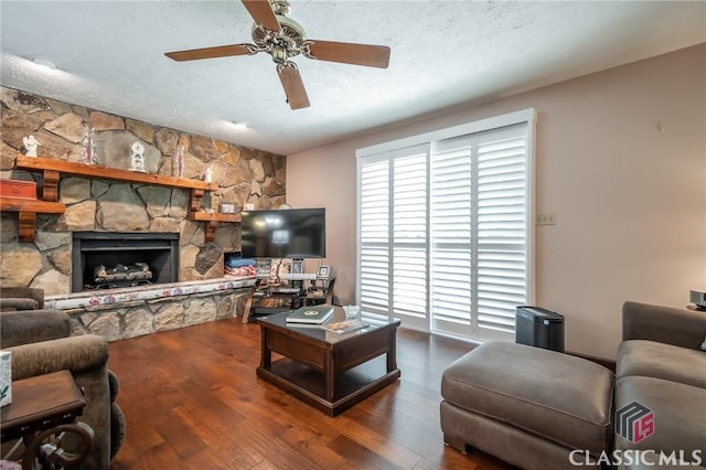749 Diamond Hill Colbert Rd, Colbert, GA 30628 - living area featuring a fireplace, a textured ceiling, wood finished floors, and a ceiling fan