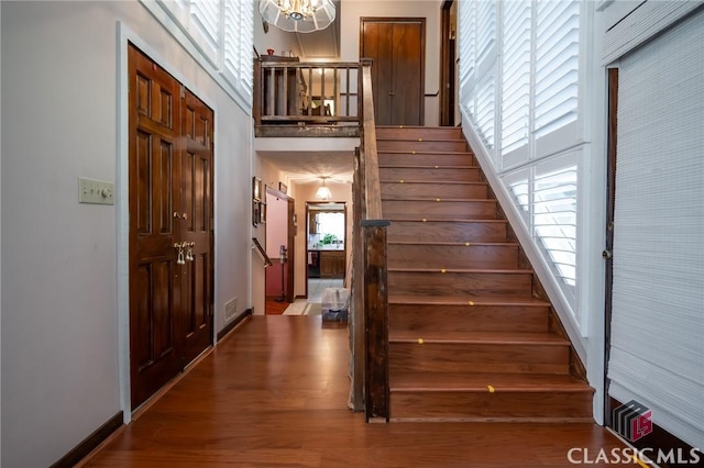 749 Diamond Hill Colbert Rd, Colbert, GA 30628 - stairway with baseboards, wood finished floors, a chandelier, and a high ceiling