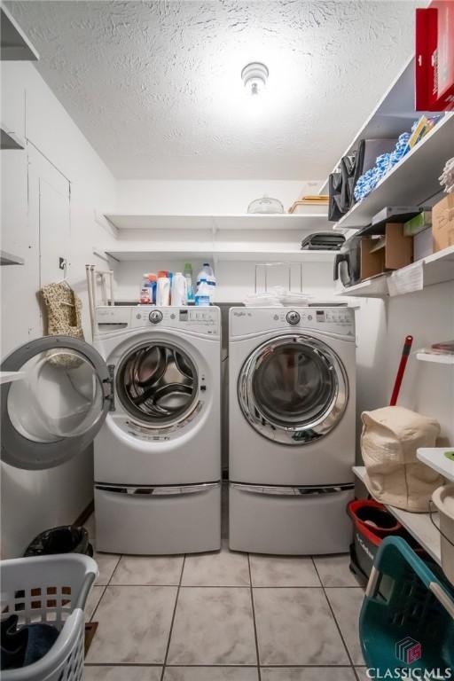 749 Diamond Hill Colbert Rd, Colbert, GA 30628 - laundry area with a textured ceiling, separate washer and dryer, laundry area, and light tile patterned floors