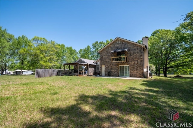 749 Diamond Hill Colbert Rd, Colbert, GA 30628 - back of property with a chimney, brick siding, a patio area, and a lawn