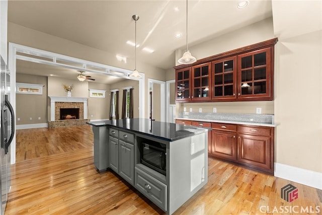 147 Rapids Dr, Bogart, GA 30622 - kitchen with built in microwave, a center island, light wood finished floors, and a brick fireplace