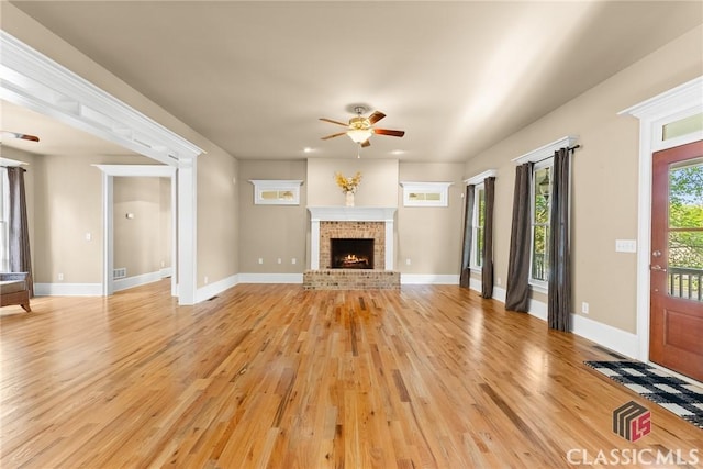 147 Rapids Dr, Bogart, GA 30622 - unfurnished living room with a brick fireplace, ceiling fan, baseboards, and light wood-style floors