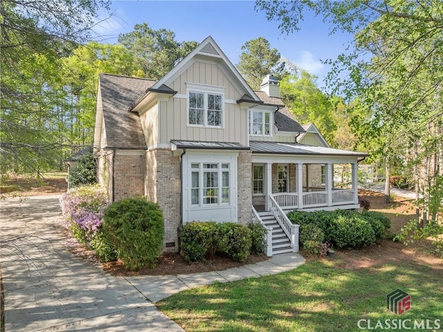 147 Rapids Dr, Bogart, GA 30622 - view of front of home with board and batten siding, stairs, a chimney, a porch, and brick siding