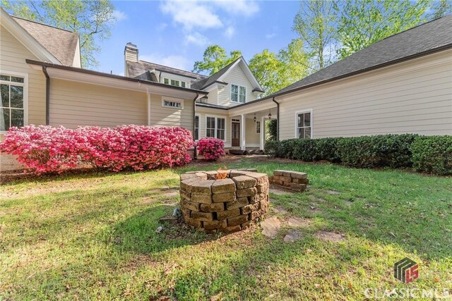 147 Rapids Dr, Bogart, GA 30622 - back of property featuring a chimney, an outdoor fire pit, and a yard