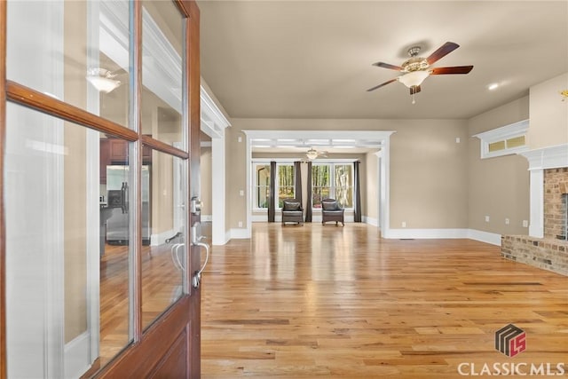 147 Rapids Dr, Bogart, GA 30622 - unfurnished living room featuring light wood finished floors, a brick fireplace, ceiling fan, baseboards, and french doors