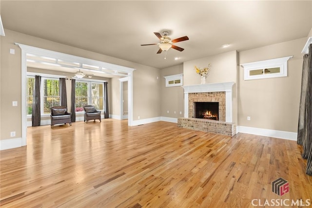 147 Rapids Dr, Bogart, GA 30622 - unfurnished living room with a brick fireplace, light wood finished floors, ceiling fan, and baseboards