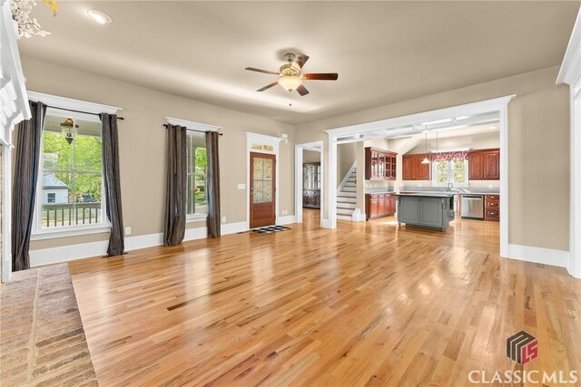 147 Rapids Dr, Bogart, GA 30622 - unfurnished living room featuring baseboards, stairway, a ceiling fan, and light wood-style floors