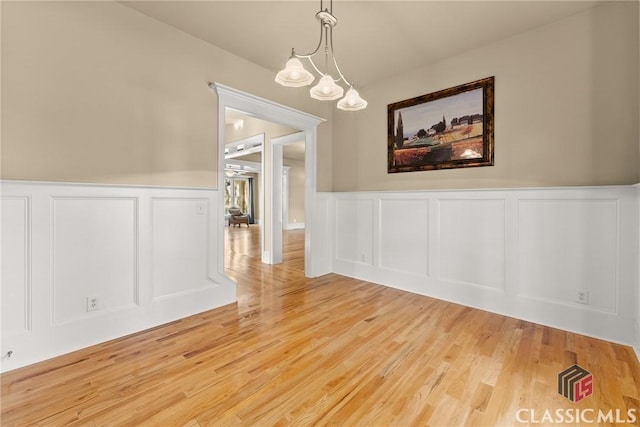 147 Rapids Dr, Bogart, GA 30622 - unfurnished dining area featuring wood finished floors, a wainscoted wall, and a decorative wall