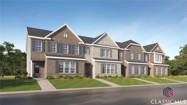 view of property with a front lawn and brick siding