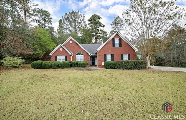 view of front of property featuring brick siding and a front yard