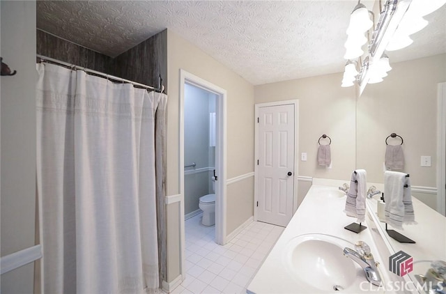 full bathroom featuring a sink, a notable chandelier, tile patterned floors, toilet, and double vanity