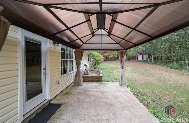 view of patio with fence, a gazebo, an outdoor structure, and a storage shed