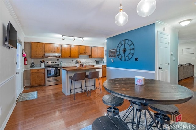 132 Tamara Ct, Athens, GA 30606 - kitchen with brown cabinetry, under cabinet range hood, appliances with stainless steel finishes, a kitchen island, and ornamental molding