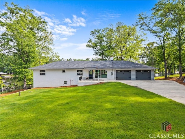 rear view of house with a lawn, a porch, driveway, and a garage