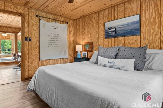 bedroom featuring wood walls, wood ceiling, and wood finished floors