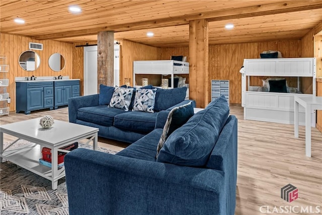 living area with light wood-style floors, wood walls, wood ceiling, and recessed lighting