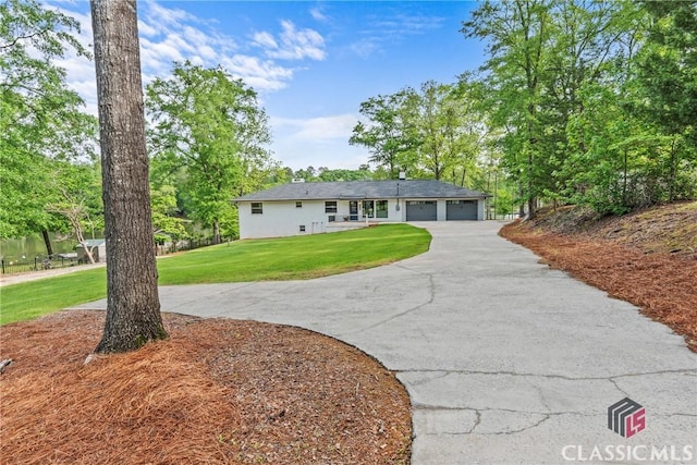 ranch-style home with a garage, aphalt driveway, and a front yard