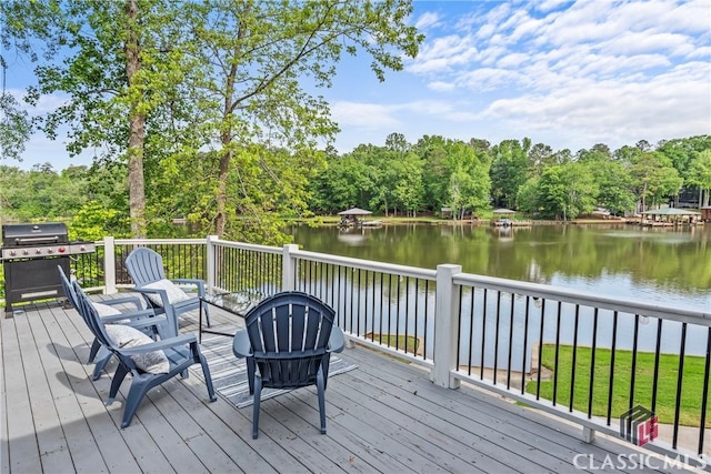 deck with a water view and area for grilling