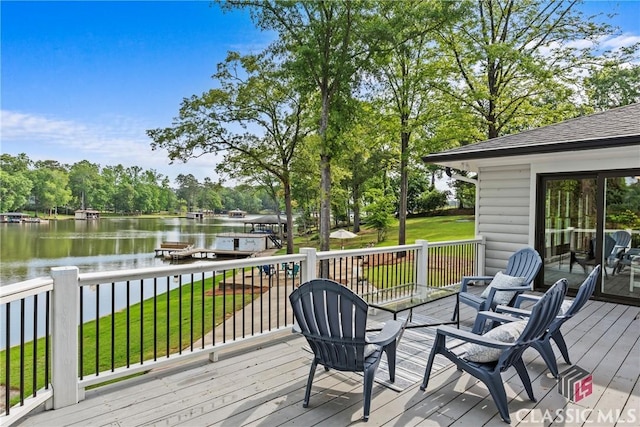wooden terrace with a water view and a yard