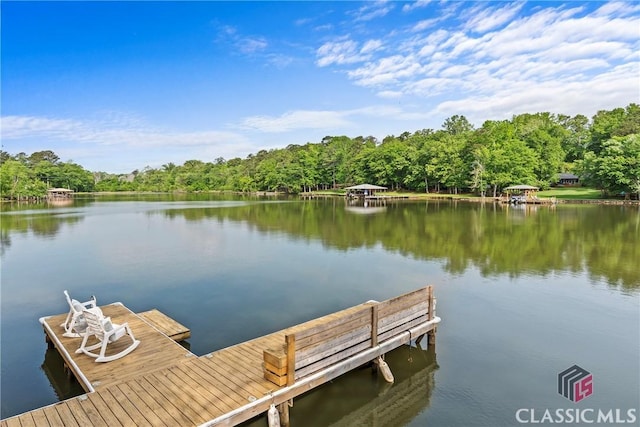 view of dock featuring a water view and a wooded view