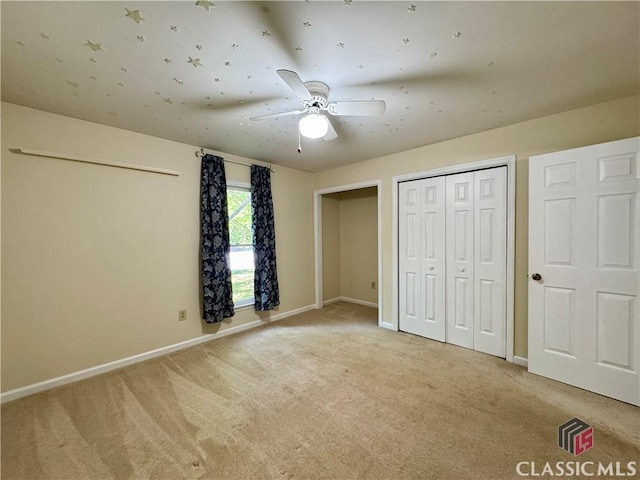 unfurnished bedroom with baseboards, ceiling fan, and light carpet