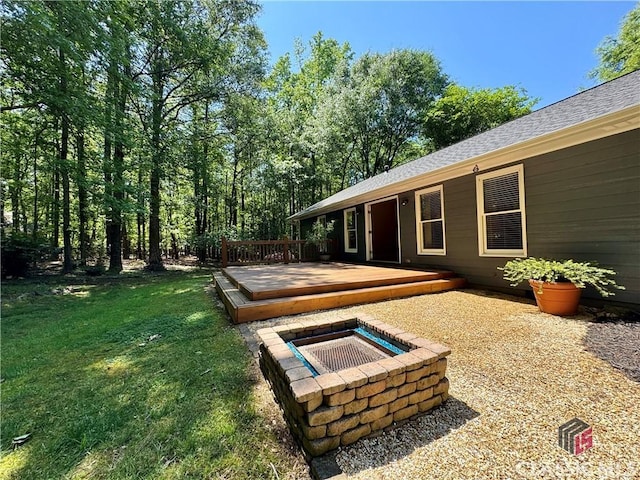 view of yard featuring an outdoor fire pit and a deck